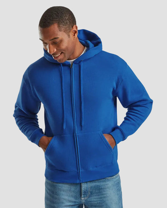 A man wearing a bright royal blue zip-up hoodie with drawstrings and front pockets, paired with blue jeans, against a solid light gray background.