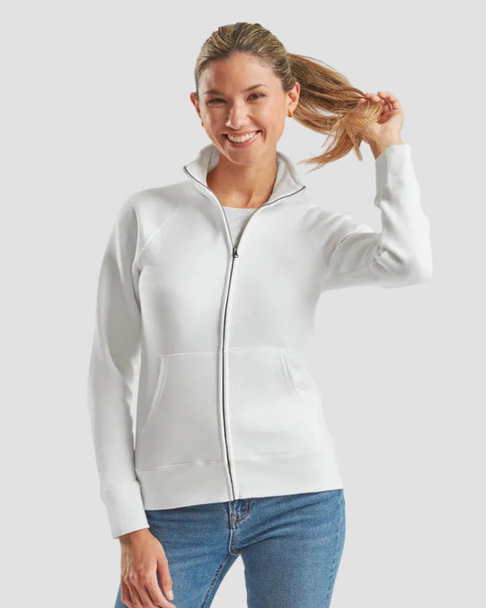 A woman wearing a white zip-up hoodie with a stand-up collar and front pockets, paired with blue jeans, against a solid light gray background.