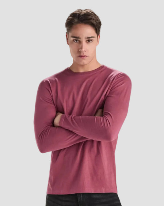 Man wearing a pink long-sleeve shirt on a white background
