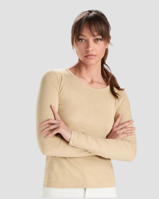 Woman wearing a beige long-sleeve top on a white background