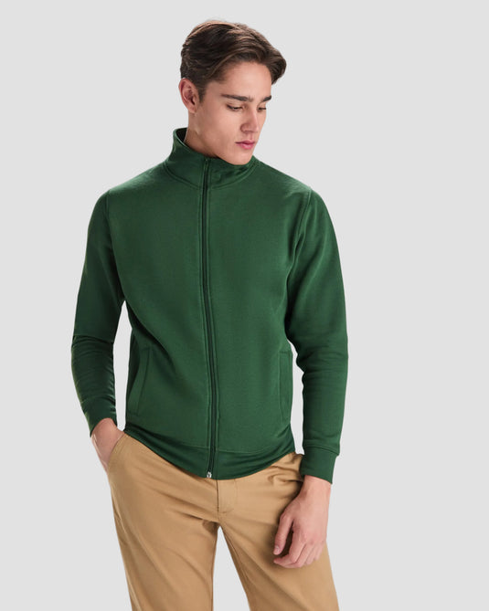Man wearing a green jacket and beige pants on a white background