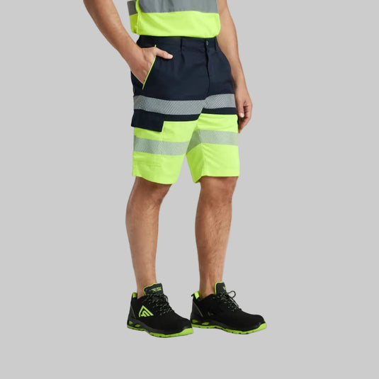Person wearing high-visibility safety shorts with reflective stripes on a plain background