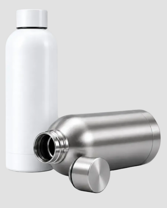 A matte white insulated bottle stands upright next to a stainless steel bottle shown open, with its cap placed in front, on a light gray background.
