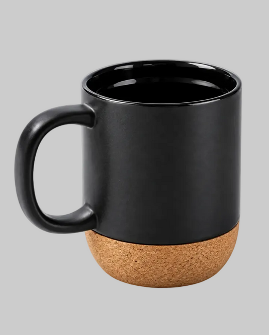 A matte black ceramic mug with a natural cork textured base, shown on a solid light gray background.