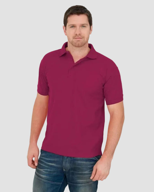 A man wearing a short-sleeve polo shirt in a deep magenta or burgundy color, paired with blue jeans, standing against a plain white background.