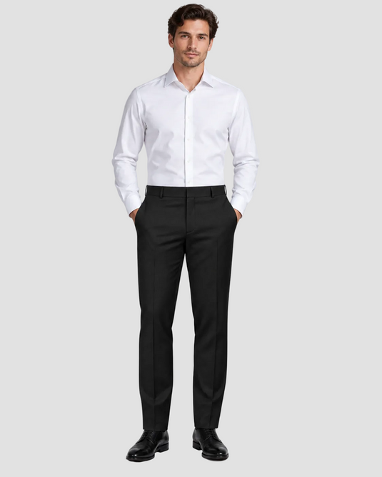 A man modeling a white long-sleeve dress shirt and black dress pants with black dress shoes, standing against a light gray studio background.