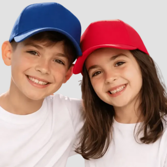 Two children wearing colorful baseball caps against a plain background
