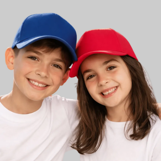 Two children wearing colorful baseball caps against a plain background