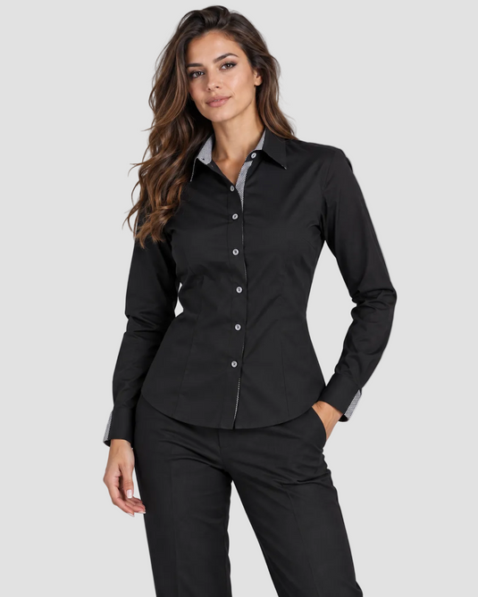 A woman modeling a black long-sleeve button-up shirt with a light gray inner collar, paired with black trousers, against a solid gray studio background.