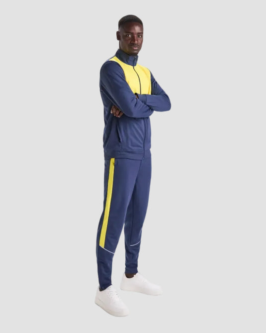 Person wearing a blue tracksuit with yellow accents on a white background