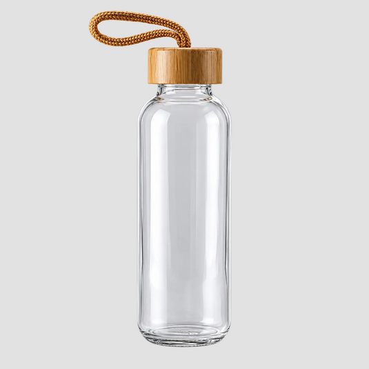 A clear glass water bottle with a light brown bamboo cap and a braided brown cord loop, shown on a neutral light gray background.
