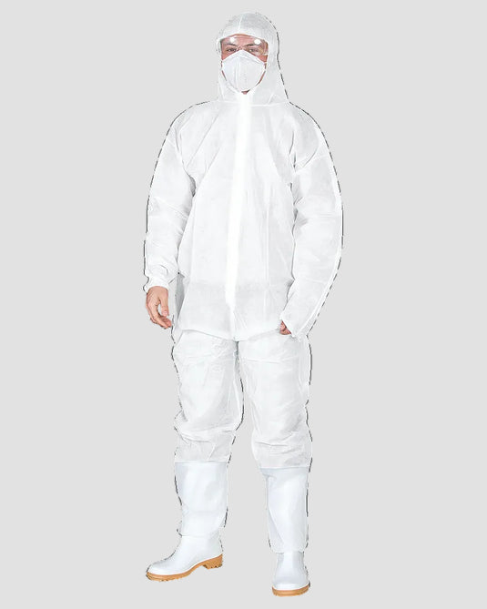 A person wearing a full-body white disposable protective suit with hood, face mask, goggles, boot covers, and white boots, photographed against a plain white studio background.