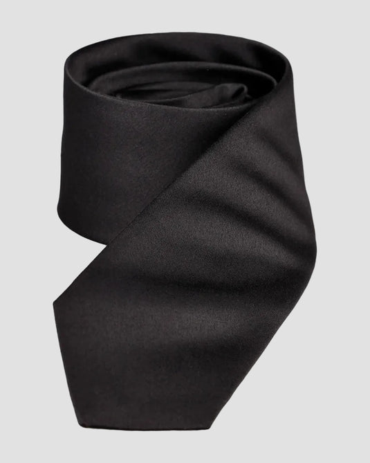 Black tie folded neatly on a light gray background