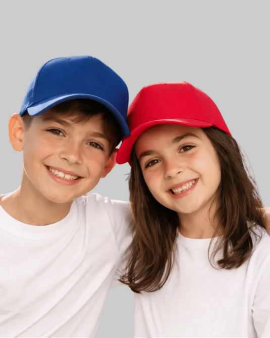 Two children wearing colorful baseball caps against a plain background