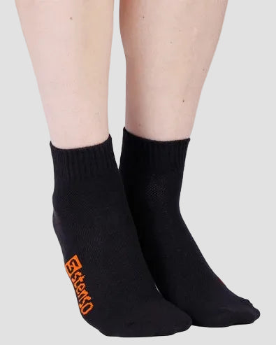 Black socks with red logo worn by a person on a light gray background